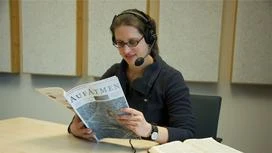 Die Sprecherin Judith Olsen liest im Tonstudio aus der Zeitschrift "Aufatmen"